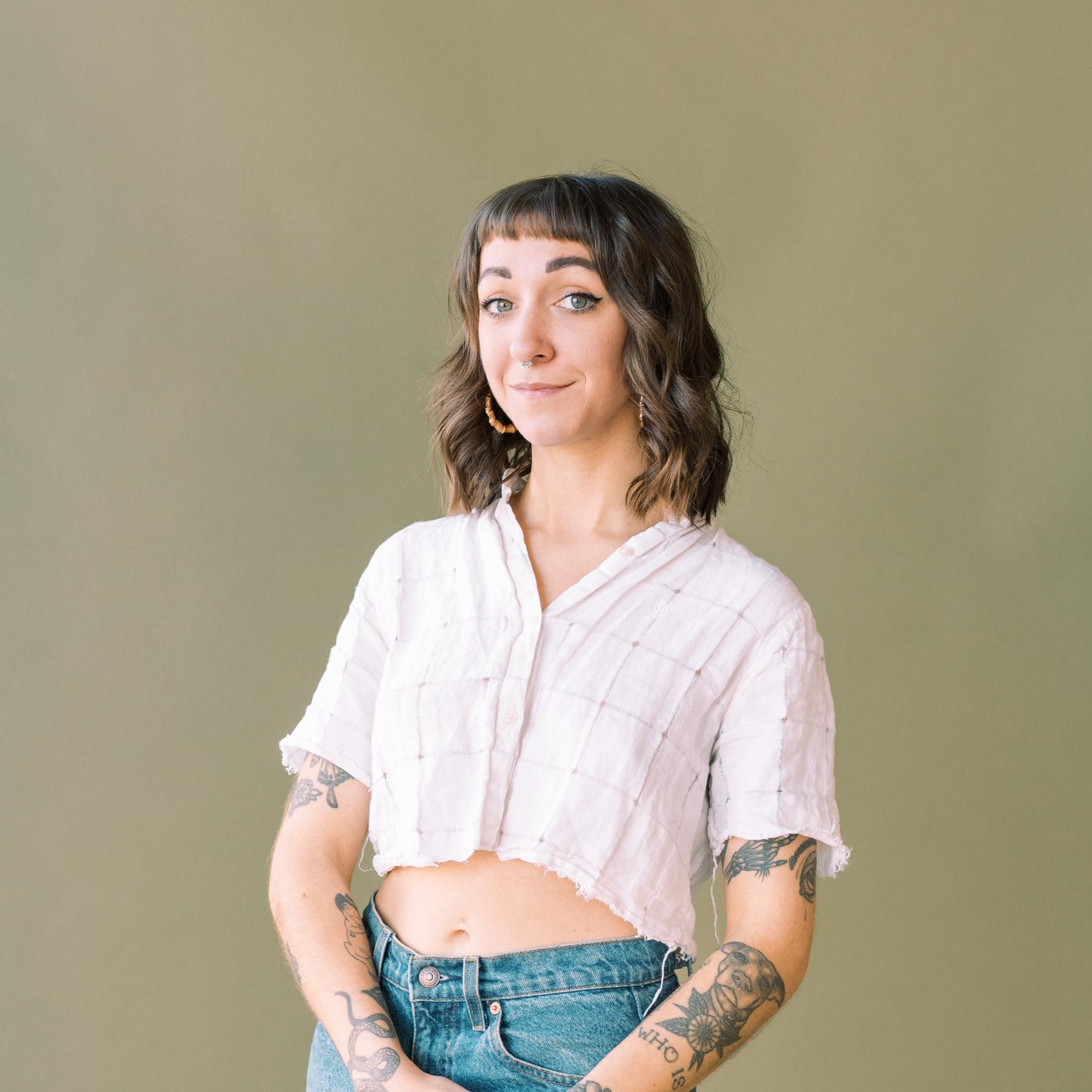 headshot of Erika Cannon, wearing a white shirt against a green backdrop.